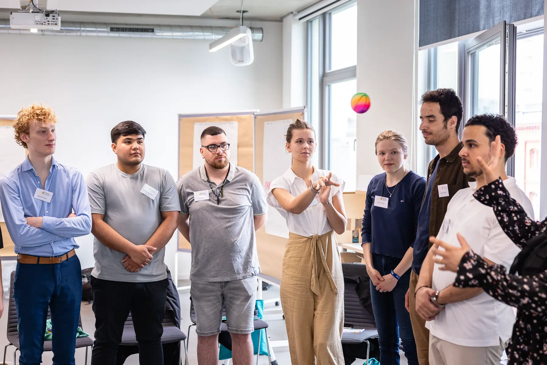 Junge Menschen werfen sich in einem Workshop einen Ball zu.